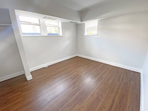A room with wooden flooring and white walls.