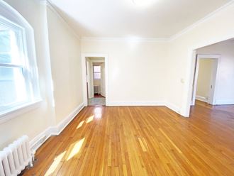 a bedroom with hardwood floors and white walls