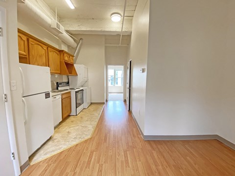 a kitchen with white appliances and wood flooring