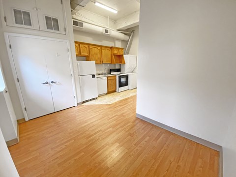 a kitchen with white appliances and wood flooring