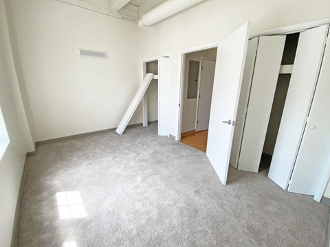 an empty room with white walls and a carpeted floor