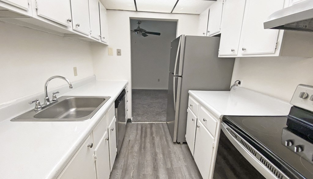 a kitchen with white cabinets and stainless steel appliances