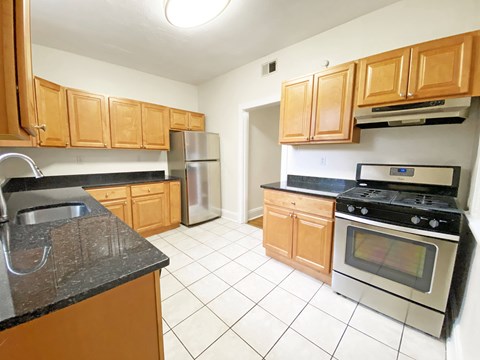 A kitchen with wooden cabinets and a black stove top oven.