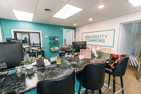 an office with a long desk with black chairs and a sign that says university commons at University Commons Apartments, Oakland, Pittsburgh