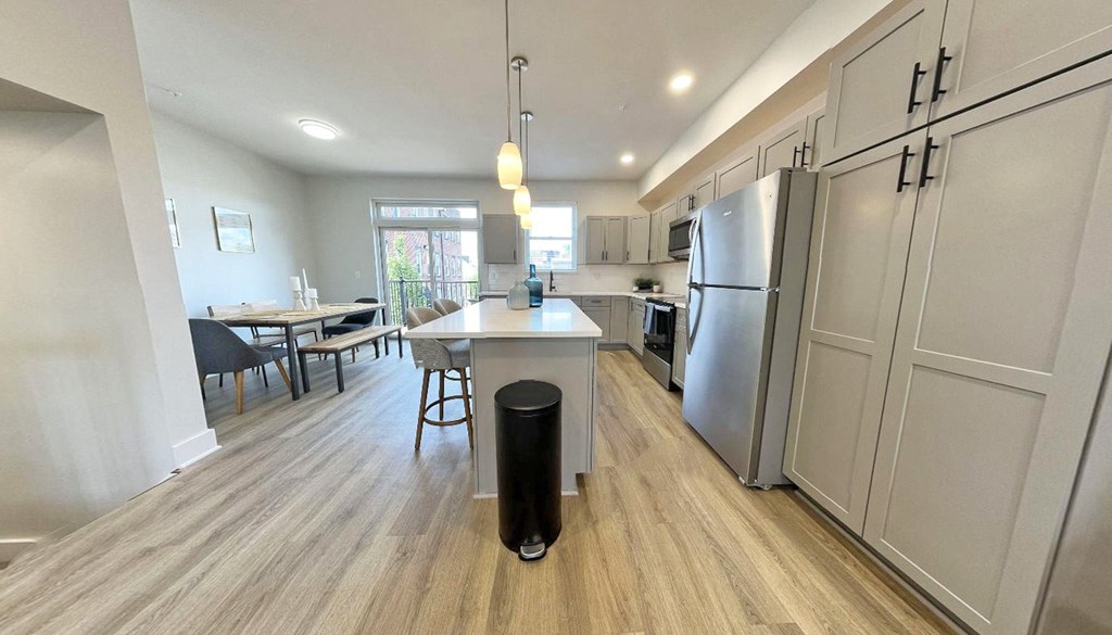 a kitchen and dining room with stainless steel appliances and wood flooring
