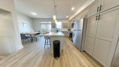 a kitchen and dining room with stainless steel appliances and wood flooring