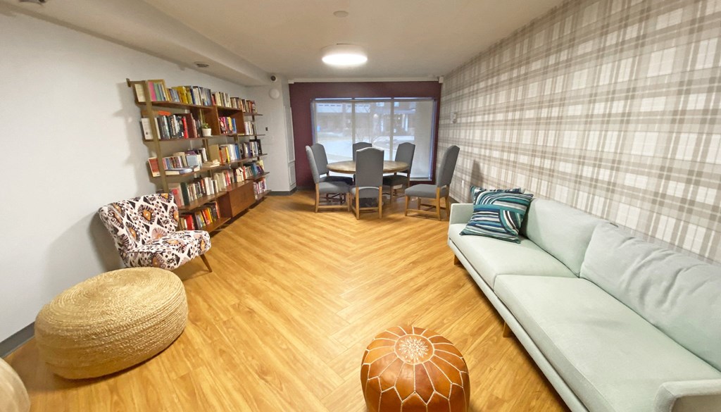a living room with a couch a table and chairs and a bookshelf