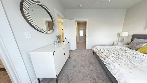 a bedroom with a bed and a mirror on the wall