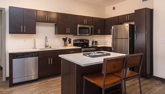 a kitchen with dark cabinets and white countertops - Photo Gallery