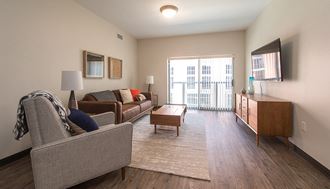 a spacious living room with a sliding glass door leading to a balcony - Photo Gallery