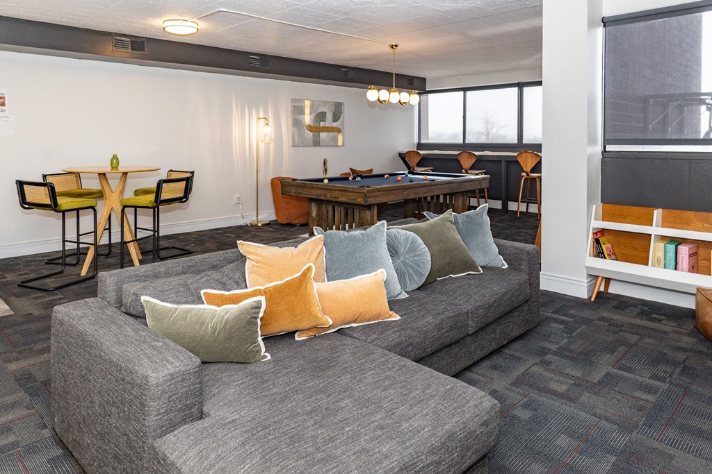 A grey couch with orange and green pillows in a room at Walnut Towers at Frick Park, Pittsburgh, PA