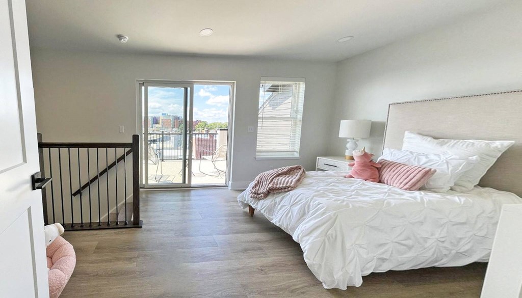 a bedroom with a bed and a door to a balcony