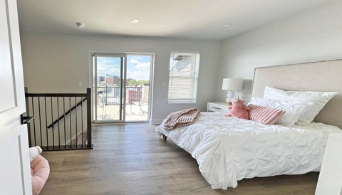 a bedroom with a bed and a door to a balcony