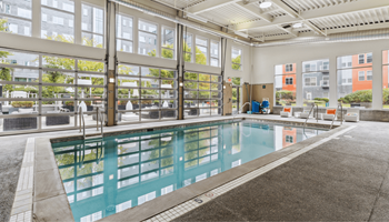 A large indoor swimming pool with a glass wall surrounding it. at Bakery Living, Pennsylvania, 15206