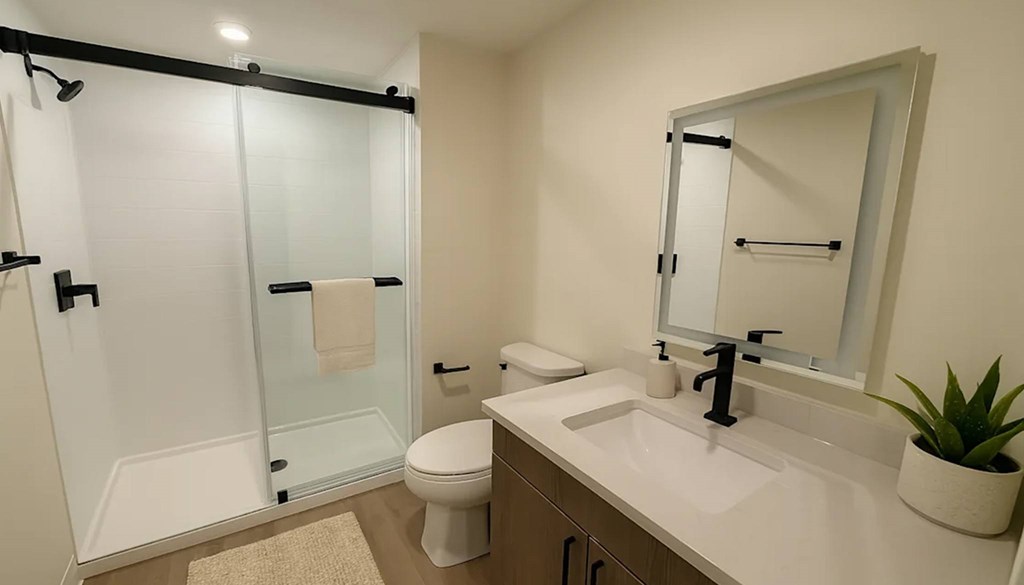A white sink with a black faucet and a mirror above it.at The Jones Tower at the Collective, Pittsburgh