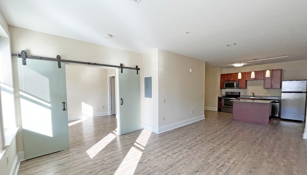 an open living room and kitchen area with a sliding barn door at Walnut on Highland, Pittsburgh, PA