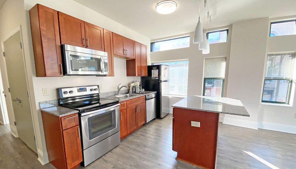 a kitchen with wooden cabinets and stainless steel appliances at Walnut on Highland, Pittsburgh, PA