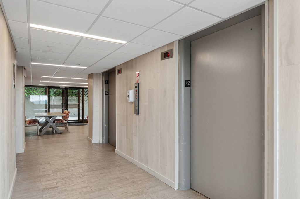 a view of a hallway with a door open and a table and chairs in the background