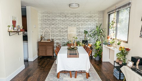 a dining room with a white tablecloth and potted plants