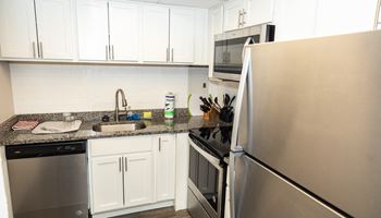 a kitchen with white cabinets and granite countertops