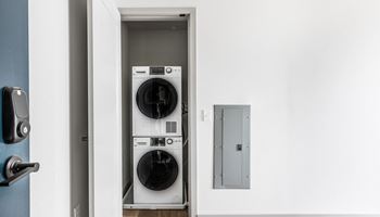 a front loading washer and dryer in a white laundry room at The Commonwealth Building, Pittsburgh, 15222