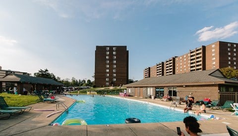 a large swimming pool with people in it and a building in the background