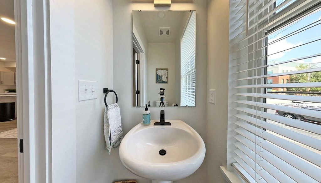 a bathroom with a sink and a mirror and a window