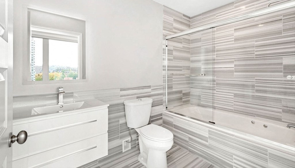 A white bathroom with a toilet, sink, and shower. at The Washington at Chatham, Pennsylvania, 15219