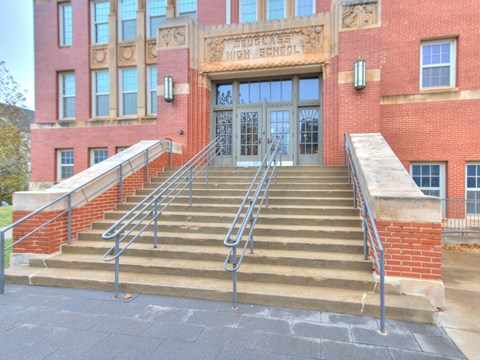 A set of stairs lead up to the entrance of a brick building.