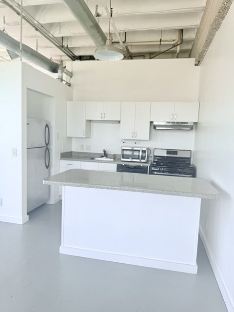 A kitchen with white cabinets and a countertop.