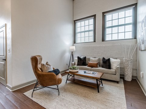 A living room with a brown chair and a white couch.