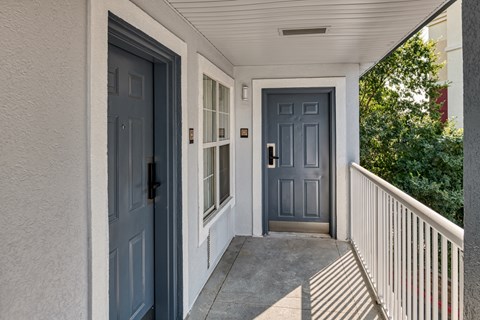 the front door of a house with blue doors and a porch