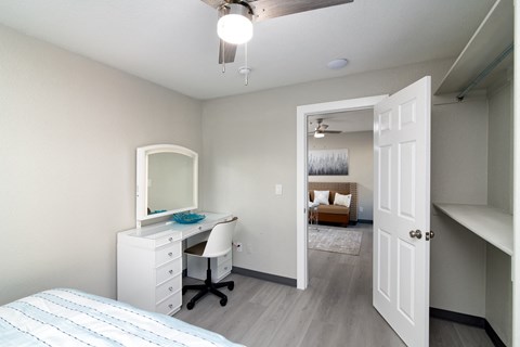 a bedroom with a desk and a mirror