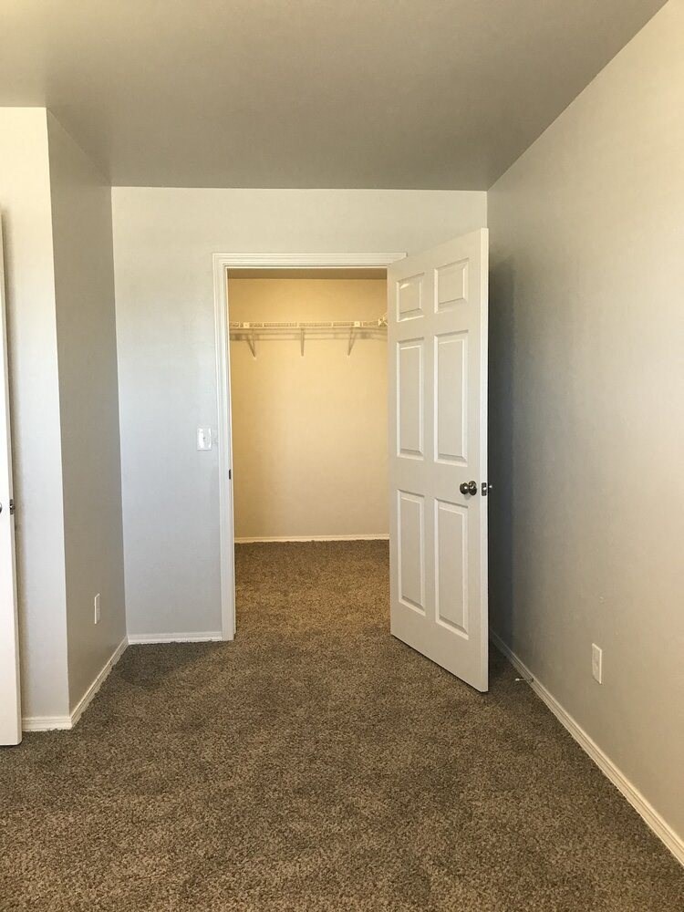 an empty room with a closet and a white door