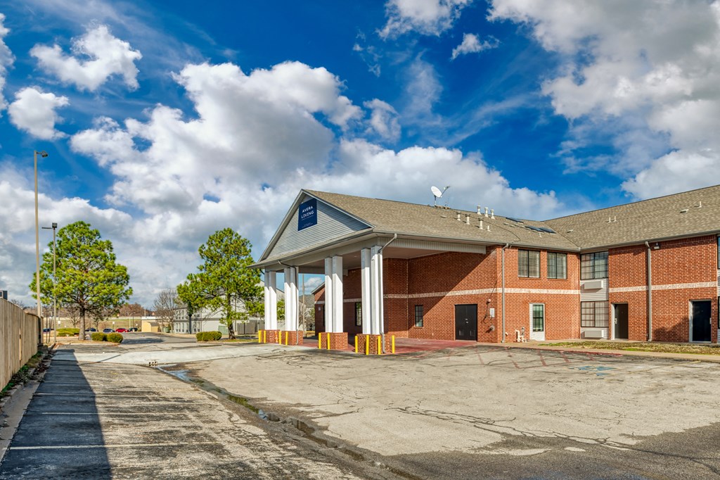 an empty parking lot in front of a brick building