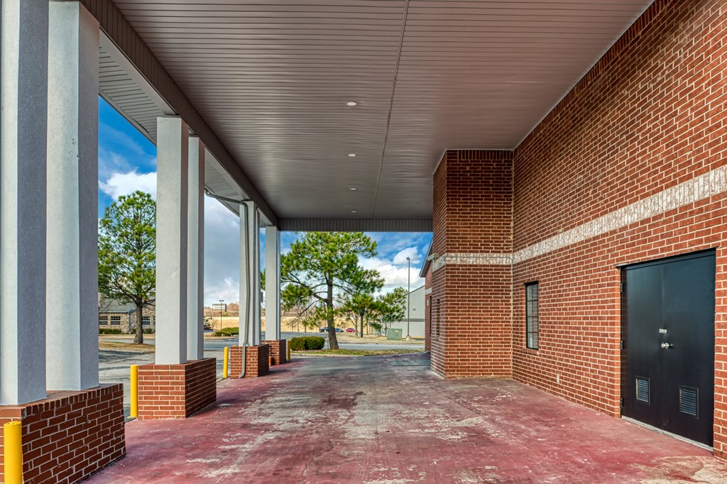 the lobby of a building with large windows and a red brick wall
