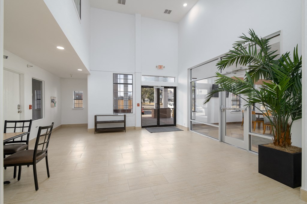 a large room with a table and chairs and a palm tree