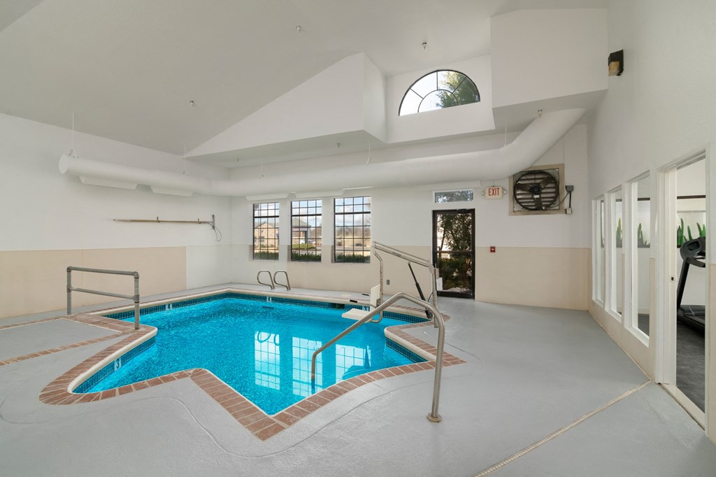 a swimming pool in the middle of a room with a glass door