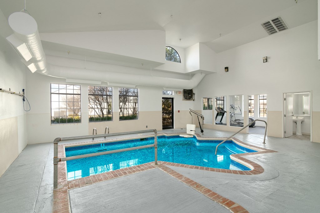 a swimming pool in the middle of a room with a large window