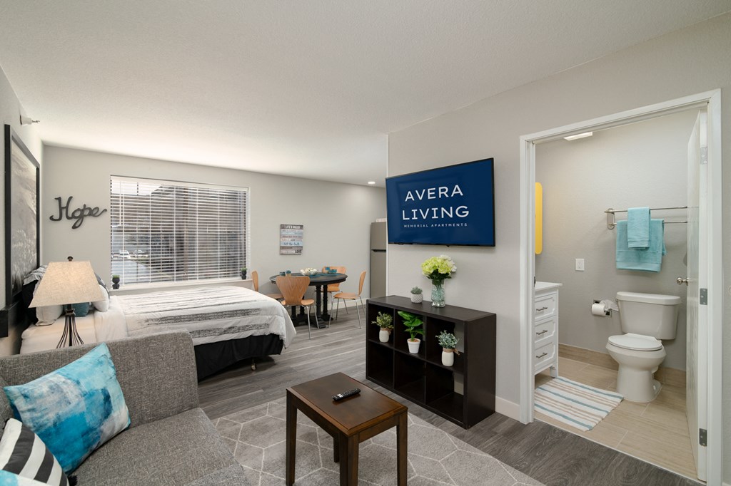 a bedroom and living room with a bed and a bathroom