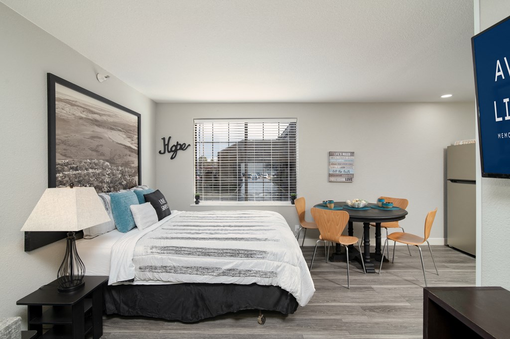 a bedroom with a large bed and a table with chairs