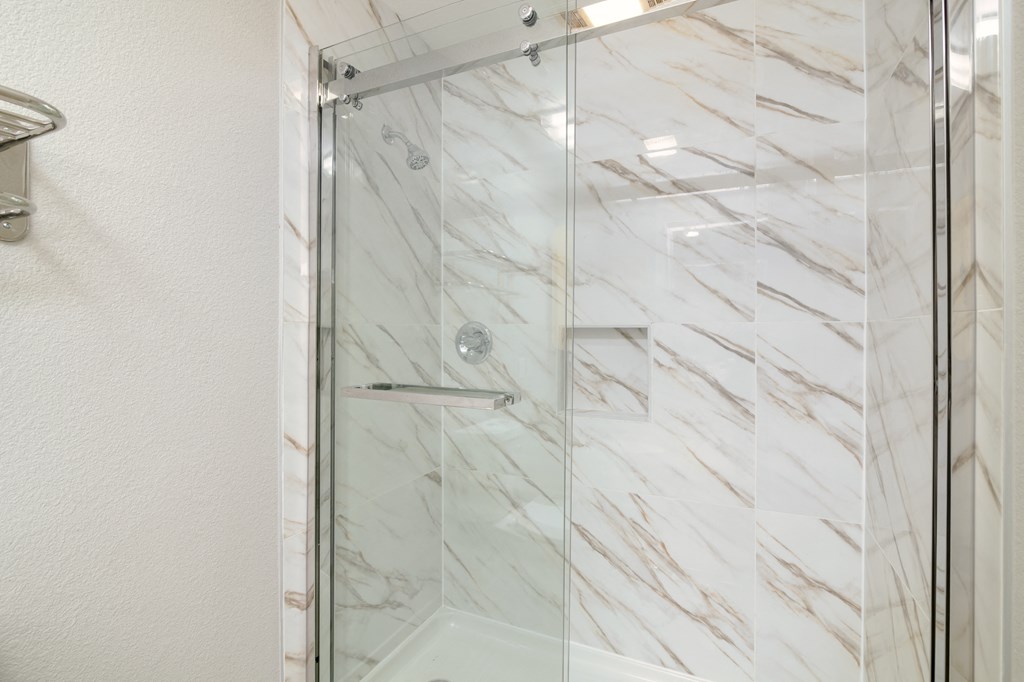 a shower with a glass door in a bathroom