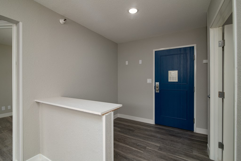 a room with a blue door and a white counter in front of it