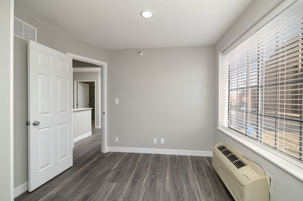 the living room of a new home with a large window and wood flooring