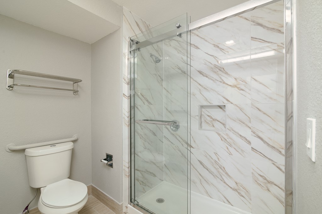 a bathroom with a glass shower and a toilet