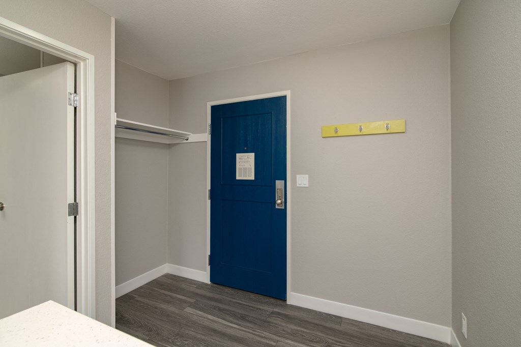 a blue door in a room with a door way to a closet