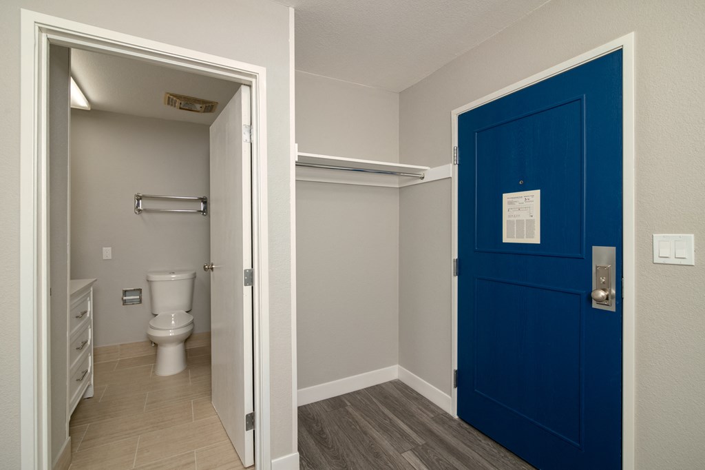 a blue door leading to a bathroom with a toilet