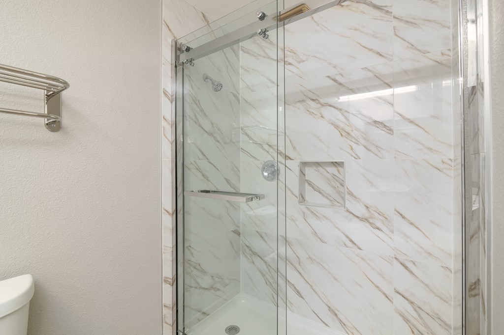 a shower with a glass door in a bathroom