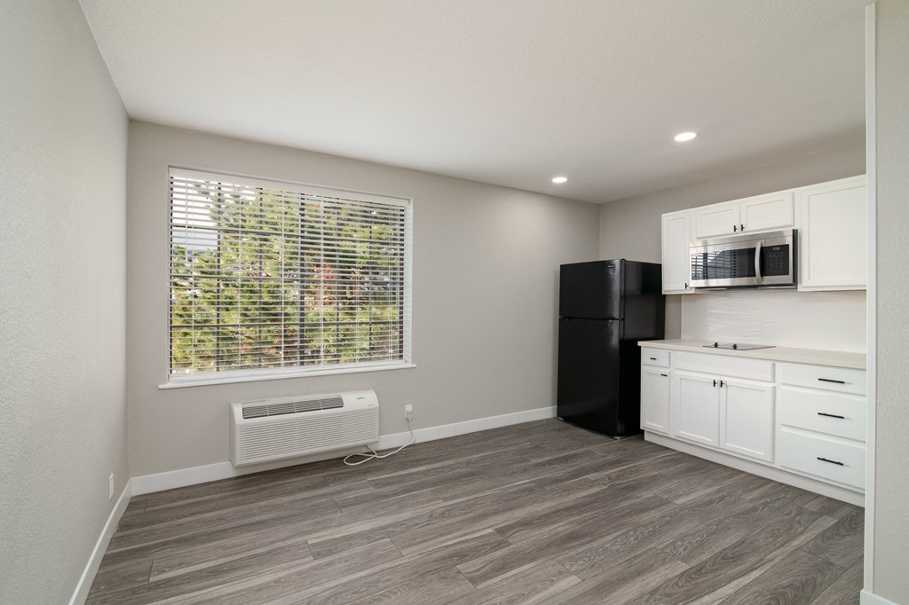 a kitchen with white cabinets and a window