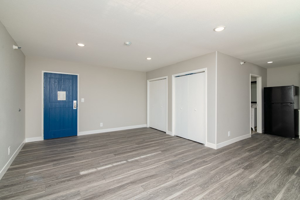 a living room with a blue door and white walls